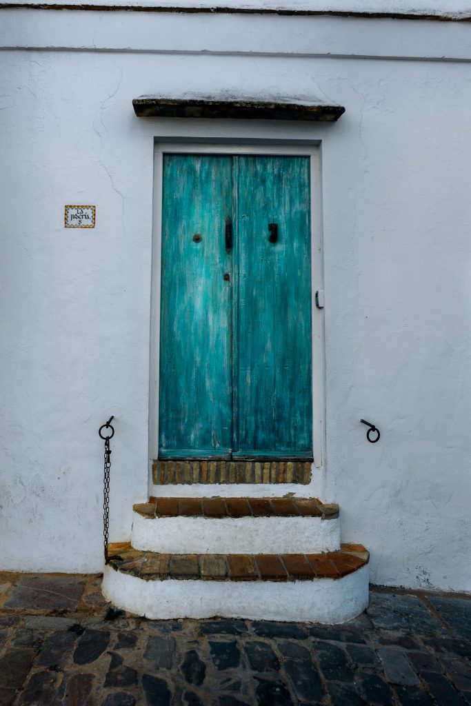Blue doors next to the Arco de la Puerta Cerrada in Vejer